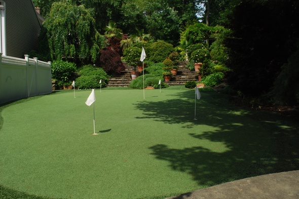 Pittsburgh Synthetic grass golf green with flags in a landscaped backyard